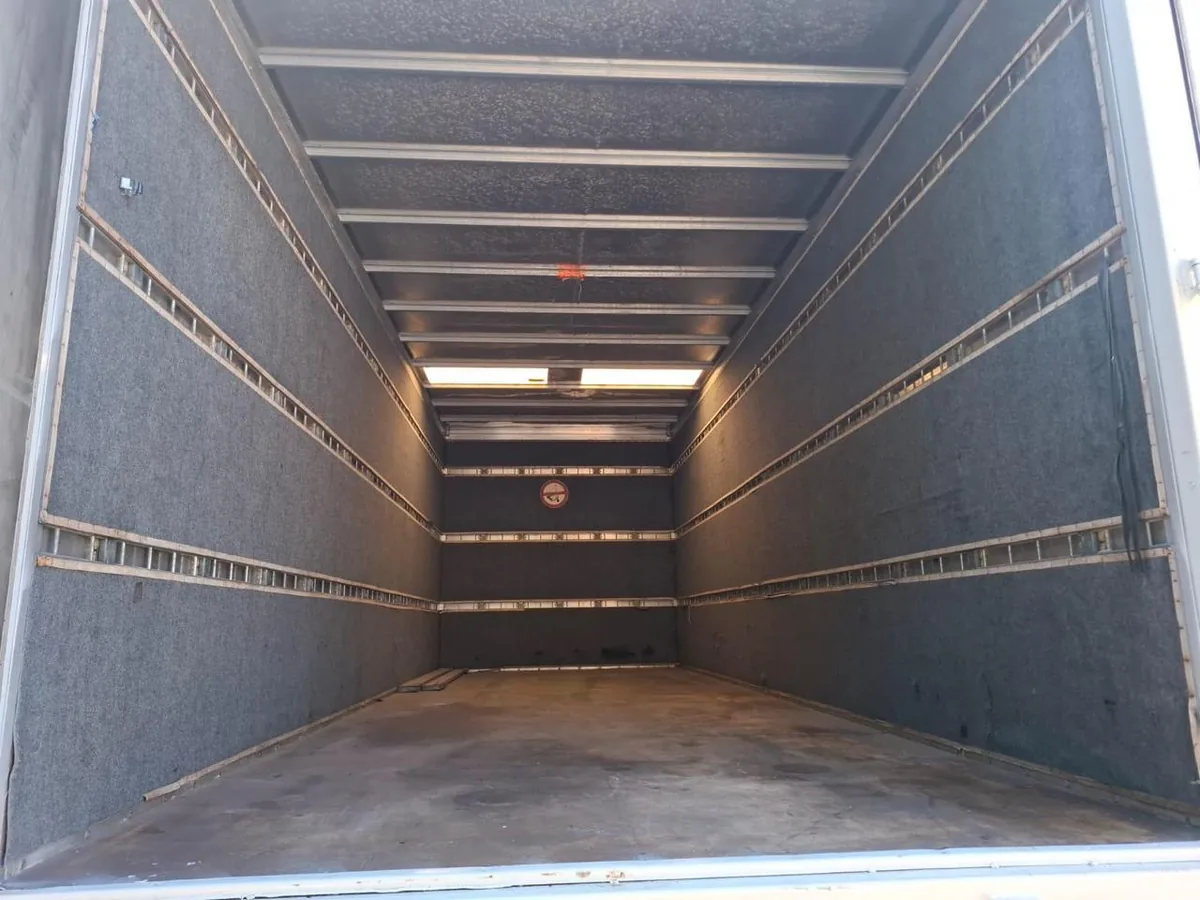 Interior de la caja del furgón vacía, forrada y con rieles de amarre